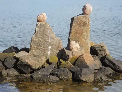 two statues sitting on rocks in the water at 5 star holiday home in Lemvig-By Traum in Lemvig