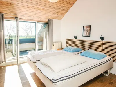 a bedroom with a large bed and a large window at 20 person holiday home in Karby-By Traum in Karby