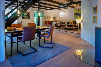 a dining room with a table and chairs and a living room at Cosy One in Struer