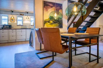 a dining room with a table and chairs and a staircase at Cosy One in Struer