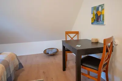 a room with a table and chairs and a bed at Cosy One in Struer