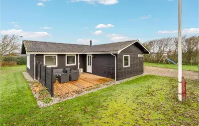 a house with a wooden deck in a yard at 4 Bedroom Cozy Home In Vinderup in Vinderup