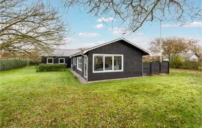 a black house in a field with a yard at 4 Bedroom Cozy Home In Vinderup in Vinderup