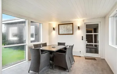 a dining room with a table and chairs and windows at 4 Bedroom Cozy Home In Vinderup in Vinderup