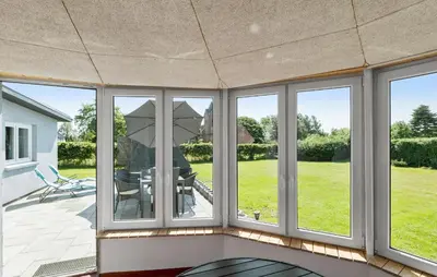 a screened in porch with a table and an umbrella at Nice Home In Roslev With Wifi in Roslev