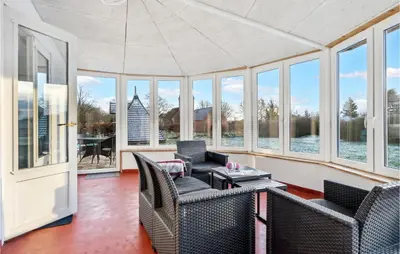 a living room with chairs and a table and windows at Nice Home In Roslev With Wifi in Roslev