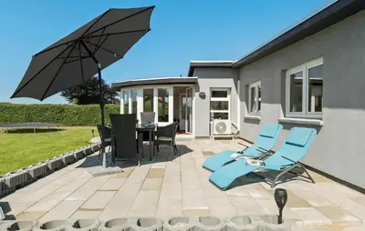 a patio with a table and chairs and an umbrella at Nice Home In Roslev With Wifi in Roslev