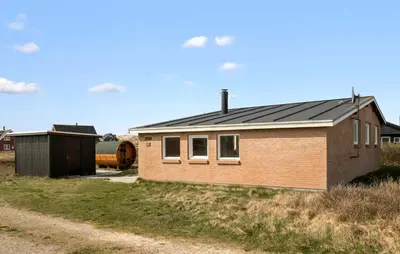 a brick house with a black roof on a field at Awesome Home In Harboøre With Wifi in Harboør