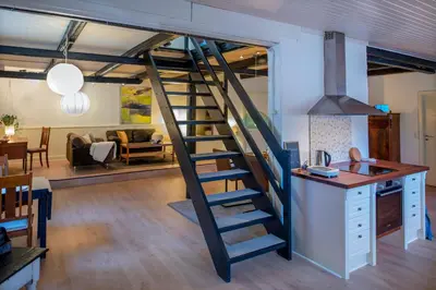 a spiral staircase in a kitchen and living room at Cosy One Villa in Struer