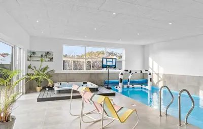 a living room with a swimming pool and a gym at Amazing Home In Blokhus With Sauna in Blokhus