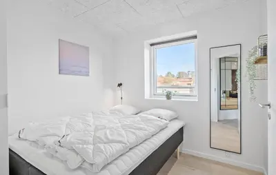 a white bedroom with a bed and a window at Amazing Home In Blokhus With Sauna in Blokhus