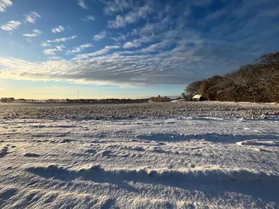 a field covered in snow under a cloudy sky at The Fishermen's House - charming and close to beach in Vang