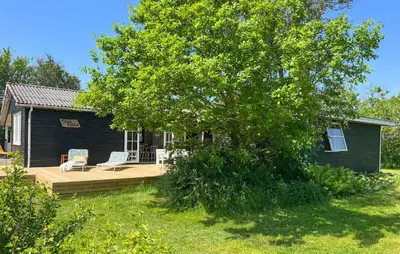 a house with a deck with two chairs and a tree at 3 Bedroom Gorgeous Home In Vinderup in Vinderup