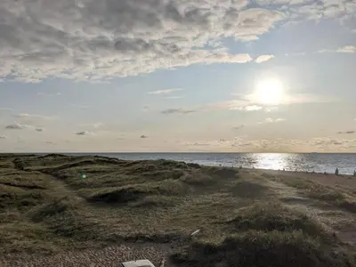 a sandy beach with the sun rising over the ocean at 6 person holiday home in Thisted-By Traum in Thisted