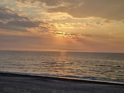a sunset over the ocean on a beach at 6 person holiday home in Thisted-By Traum in Thisted