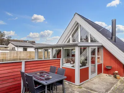 a red house with a table and chairs at 6 person holiday home in Thisted-By Traum in Thisted