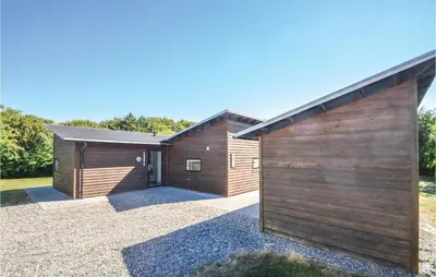 a house with a wooden exterior with a garage at Holiday Home Vestervig 44 in Vestervig