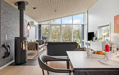 a living room with a fireplace and a table and chairs at Holiday Home Vestervig 44 in Vestervig