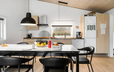 a kitchen with a table and chairs and a kitchen with a table and chairsktop at Holiday Home Vestervig 44 in Vestervig