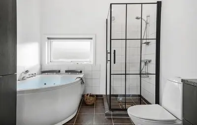 a bathroom with a tub and a toilet and a shower at Holiday Home Vestervig 44 in Vestervig