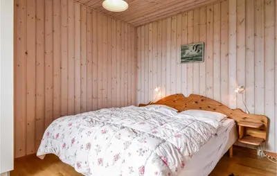 a bedroom with a bed with a wooden wall at Holiday Home Lemvig 12 in Lemvig