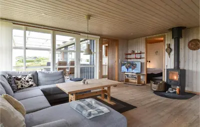 a living room with a couch and a table and a tv at Holiday Home Lemvig 12 in Lemvig