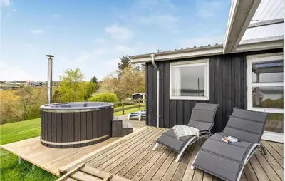 a deck with a hot tub and chairs on a house at Holiday Home Lemvig 12 in Lemvig