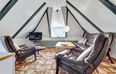 a living room with leather chairs and a tv at Holiday Home Thyholm 12 in Thyholm