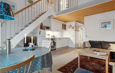 a living room with a dining room table and a kitchen at Pet Friendly Apartment In Vestervig in Vestervig