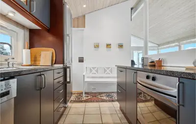 a kitchen with stainless steel appliances and a large window at Awesome Home In Saltum With Kitchen in Saltum