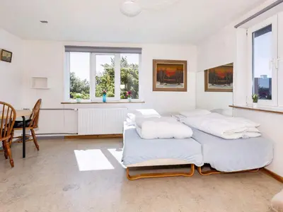 a bedroom with two beds and a table and chairs at 12 person holiday home in Roslev-By Traum in Roslev