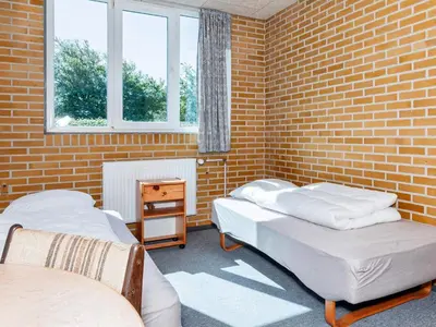 two beds in a room with a brick wall at 12 person holiday home in Roslev-By Traum in Roslev