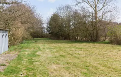 a large grass field with trees in the background at 5 Bedroom Gorgeous Home In Thyholm in Thyholm