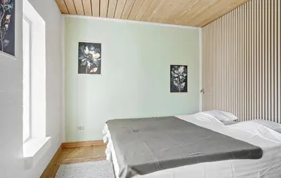 a bedroom with a bed and two pictures on the wall at 5 Bedroom Gorgeous Home In Thyholm in Thyholm