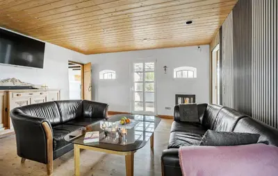 a living room with two leather couches and a table at 5 Bedroom Gorgeous Home In Thyholm in Thyholm