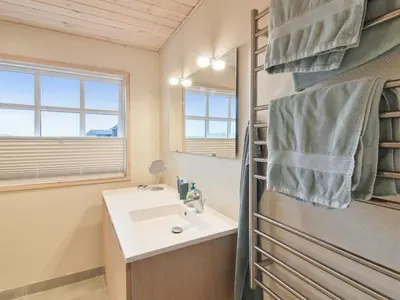 a bathroom with a sink and a mirror at Holiday Home Merina - 150m from the sea by Interhome in Løkken