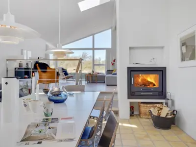 a kitchen and living room with a fireplace in a room at Holiday Home Annrike - 400m from the sea by Interhome in Saltum
