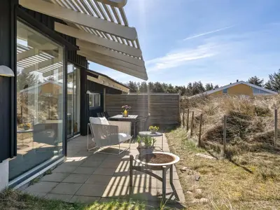 a patio of a house with a table and chairs at Holiday Home Annrike - 400m from the sea by Interhome in Saltum