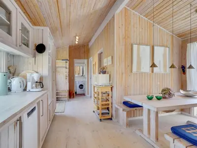 a kitchen with wooden walls and a wooden ceiling at Holiday Home Nikodina - 200m from the sea by Interhome in Saltum