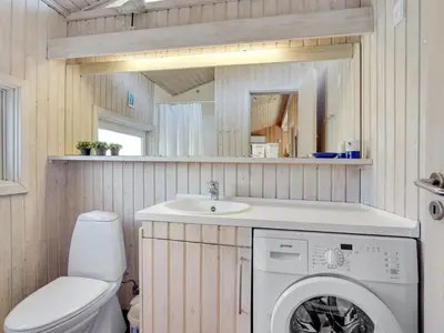 a bathroom with a washing machine and a sink at Holiday Home Nikodina - 200m from the sea by Interhome in Saltum