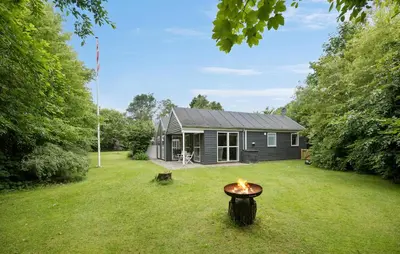 a small house in a yard with a fire pit at Amazing Home In Farsø With Sauna in Farsø