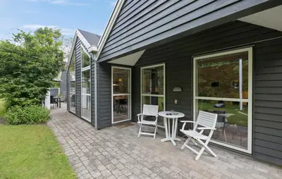 a patio with chairs and a table on the side of a house at Amazing Home In Farsø With Sauna in Farsø