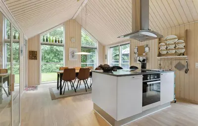 a kitchen and dining room with a stove and a table at Amazing Home In Farsø With Sauna in Farsø