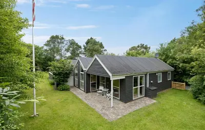 a black tiny house in a garden at Amazing Home In Farsø With Sauna in Farsø