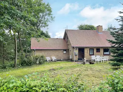 a house with chairs and a yard in front of it at 2 person holiday home in Snedsted-By Traum in Snedsted