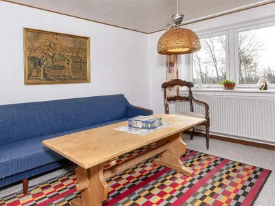 a living room with a blue couch and a table at 2 person holiday home in Snedsted-By Traum in Snedsted