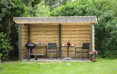 a barbecue grill and chairs in front of a wooden shed at Cozy Apartment In Ranum With Wifi in Ranum