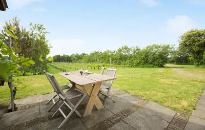 a wooden table and chairs sitting on a patio at Cozy Apartment In Ranum With Wifi in Ranum