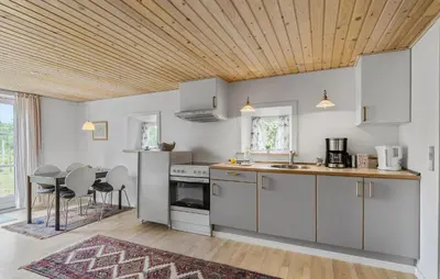 a kitchen with white cabinets and a wooden ceiling at Cozy Apartment In Ranum With Wifi in Ranum