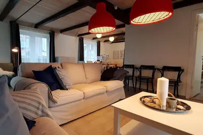 a living room with a couch and a table at Centralt by hus Blokhus-Hune til 10 pers privat Gårdhave in Blokhus